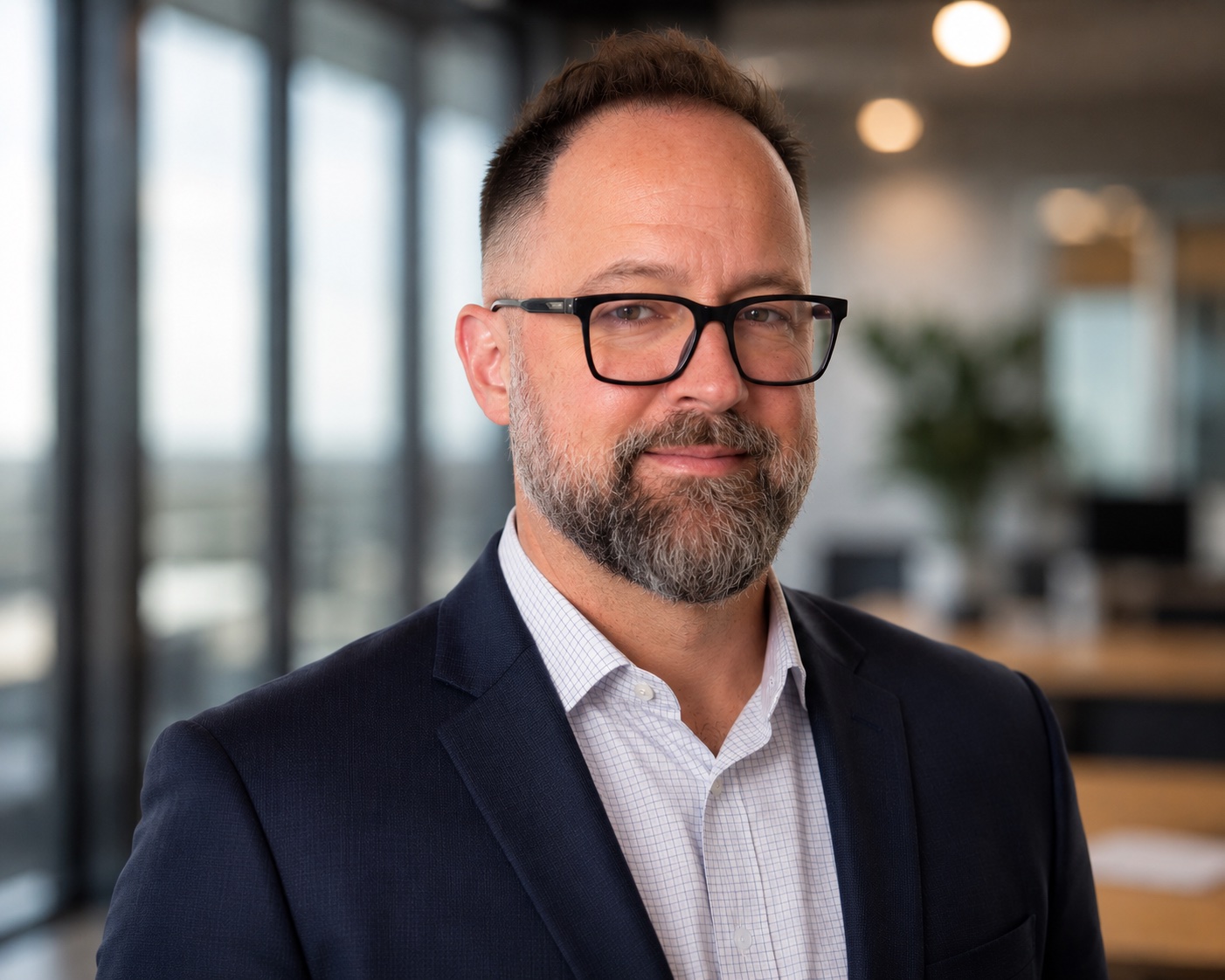 Peter Nuffer wearing glasses and a navy jacket in an office